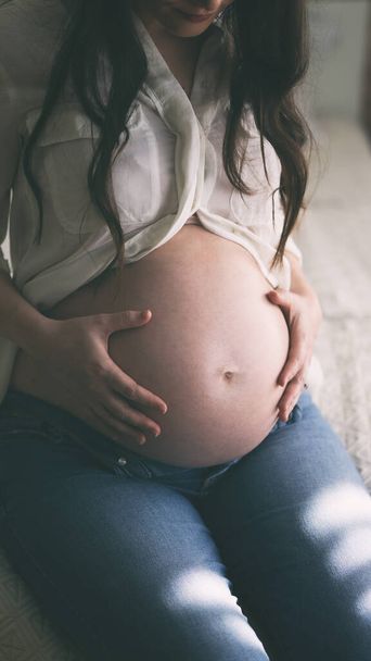 Pregnant woman belly holding hands - Foto, Imagem