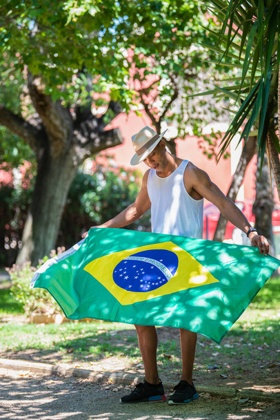 Latino-Mann mit Hut in Brasilien-Flagge: Selektiver Fokus. Diversitätskonzept. - Foto, Bild
