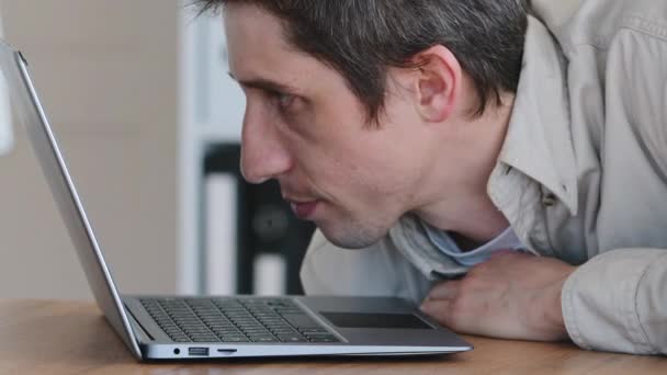 Portret van de blanke man millennial luie werknemer slapen ligt op laptop in het kantoor aan tafel op het werk voelt moe uitputting wakker antwoord op e-mail typen op toetsenbord met neus dutten - Video