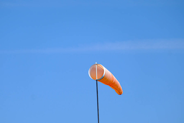 orangefarbene Windsocke fliegt im Wind, um die Windrichtung anzuzeigen - Foto, Bild