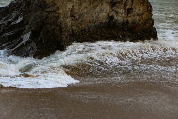 Onde di tempesta atlantica si infrangono e si riversano su rocce e sabbia sulla spiaggia della baia di Carlyon in Cornovaglia, sulla costa sud-occidentale dell'Inghilterra - Foto, immagini