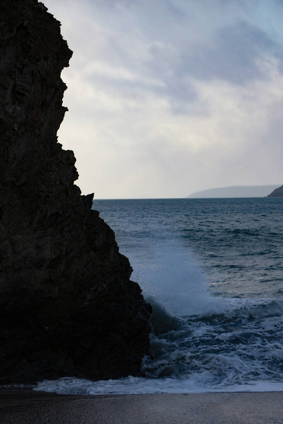 Κύματα καταιγίδας στον Ατλαντικό πέφτουν και πλένονται πάνω από βράχους και άμμο στην παραλία του κόλπου Carlyon στην Κορνουάλη στη νοτιοδυτική ακτή της Αγγλίας - Φωτογραφία, εικόνα