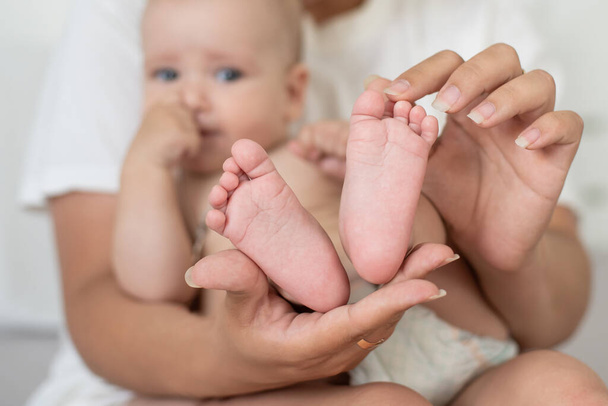 Родитель держит в руках ноги новорожденного ребенка - Фото, изображение