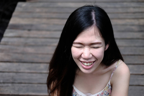 Nuori aasialainen kaunis nainen hymyilee ja nauraa puisella sillalla luonnonpuistossa - Valokuva, kuva