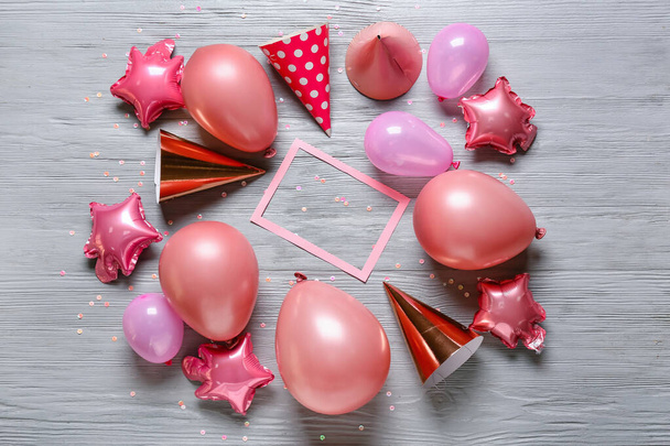 Σύνθεση με χάρτινο σκελετό, αερόστατα και καπέλα πάρτι σε γκρι ξύλινο φόντο - Φωτογραφία, εικόνα