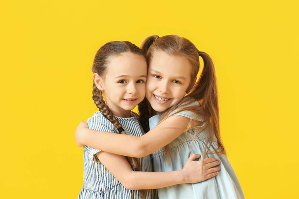 Χαριτωμένες μικρές αδελφές στο φόντο χρώμα - Φωτογραφία, εικόνα