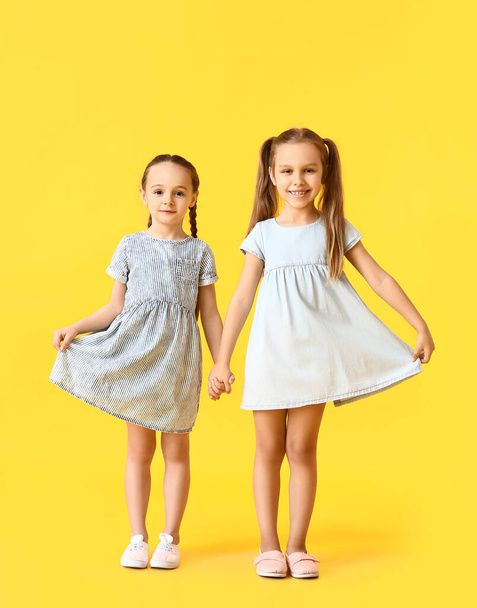 Cute little sisters on color background - Foto, Bild