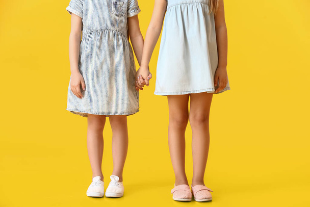 Cute little sisters on color background - Photo, image