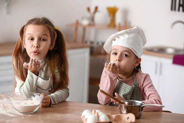 Cute little sisters blowing kiss in kitchen - Photo, Image