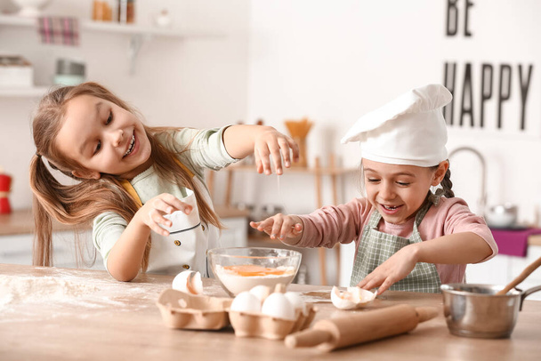 Cute little sisters cooking in kitchen - Zdjęcie, obraz