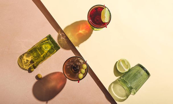 Sklenice chutných koktejlů s limetkou a olivami na barevném pozadí - Fotografie, Obrázek