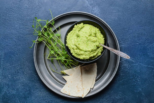 Mísa s chutným zeleným hráškem hummus a pita na barevném pozadí - Fotografie, Obrázek