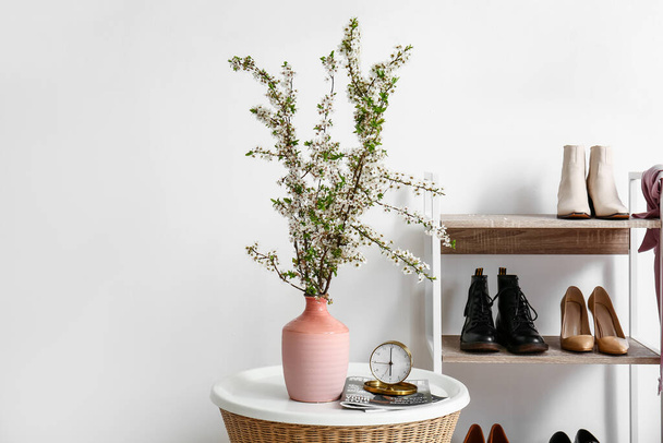 Vase with beautiful blossoming branches on table in room - Фото, зображення