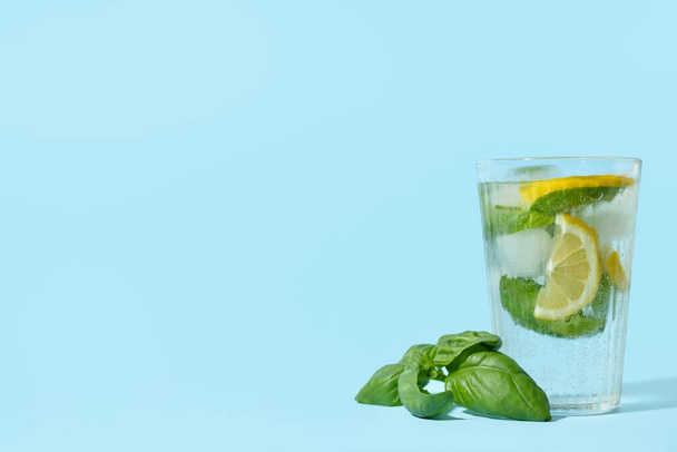 Glass of tasty lemonade with basil on background - Foto, Imagen