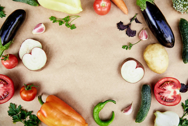 Vegetable frame: beet, basil, eggplant, parsley, bell pepper, hot pepper, potatoes, cucumber, carrots. Italian vegetable recipe. Veganism concept food.Top view, copy space - Photo, image