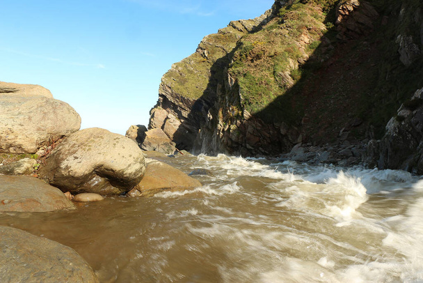 Der Heddon-Fluss ist auf dem Weg zur See an der Küste von North Devon im Südwesten Englands durch schwere Regenfälle und Hochwasser angeschwollen. - Foto, Bild