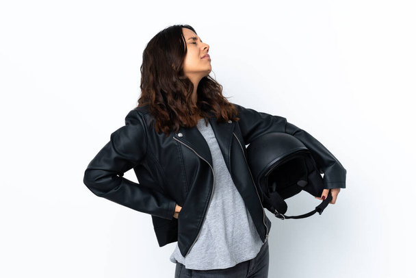 Young woman holding a motorcycle helmet over isolated white background suffering from backache for having made an effort - Φωτογραφία, εικόνα