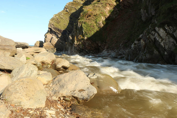 Der Heddon-Fluss ist auf dem Weg zur See an der Küste von North Devon im Südwesten Englands durch schwere Regenfälle und Hochwasser angeschwollen. - Foto, Bild