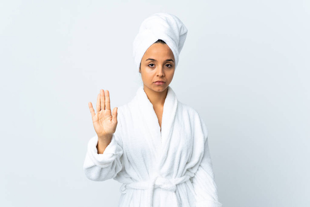 Jovem mulher em roupão de banho sobre fundo branco isolado fazendo parar gesto - Foto, Imagem