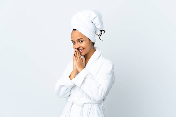 Young woman in bathrobe over isolated white background keeps palm together. Person asks for something - Foto, afbeelding