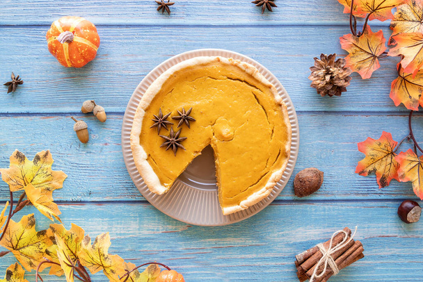 Autumn concept. Homemade pumpkin pie with autumn leaves on rustic background, top view flat lay - Foto, imagen