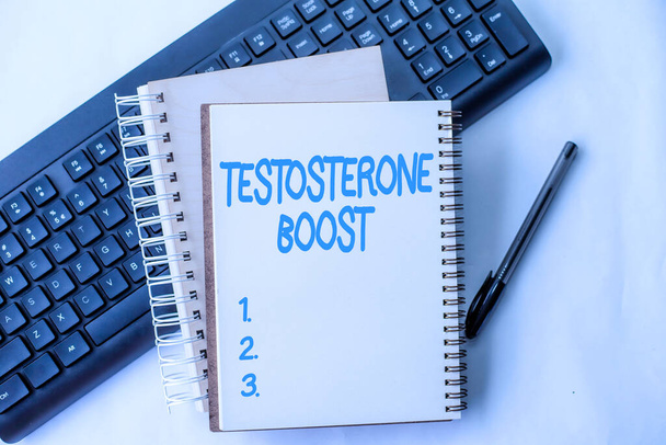 Text caption presenting Testosterone Boost. Conceptual photo rise of primary male sex hormone and an anabolic steroid Two Plain Lined Spiral Notebooks With Pen And Keyboard On Table. - 写真・画像
