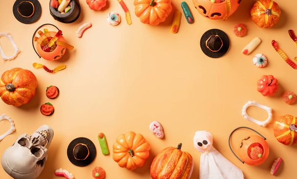 Halloween-Dekoration mit Kürbissen und Bonbons Draufsicht auf orangefarbenem Hintergrund mit Kopierfläche - Foto, Bild