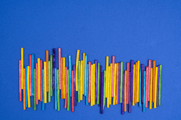 some multicolored sticks on a blue surface - Zdjęcie, obraz