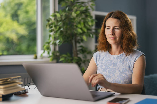 Woman using laptop for work - Фото, изображение