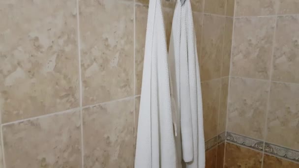 4k video, Držák kovových ručníků v koupelně se dvěma bílými froté ručníky - Záběry, video