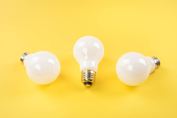 Opaque white bulbs on yellow background - Fotó, kép