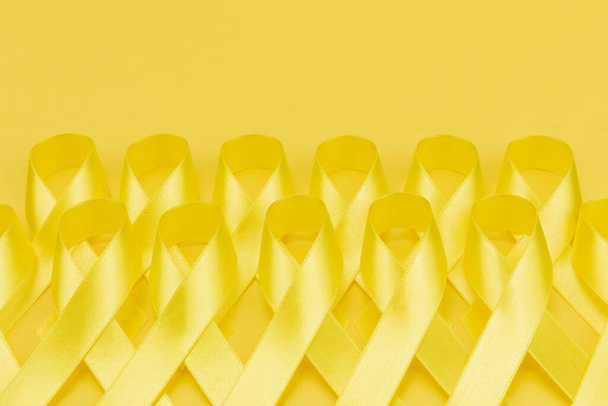 Yellow ribbons on yellow background - Φωτογραφία, εικόνα