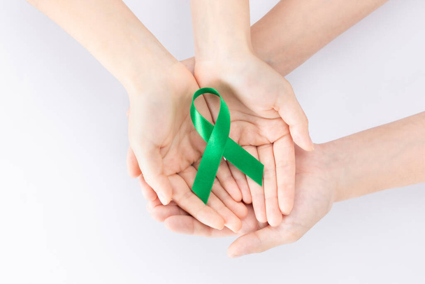 two persons holding green ribbon - Φωτογραφία, εικόνα