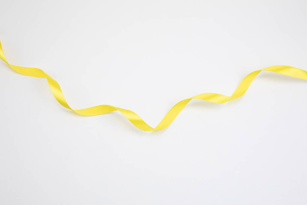 long yellow ribbon, white background - 写真・画像
