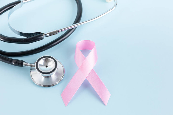 stethoscope and pink ribbon, sky blue background - Foto, afbeelding