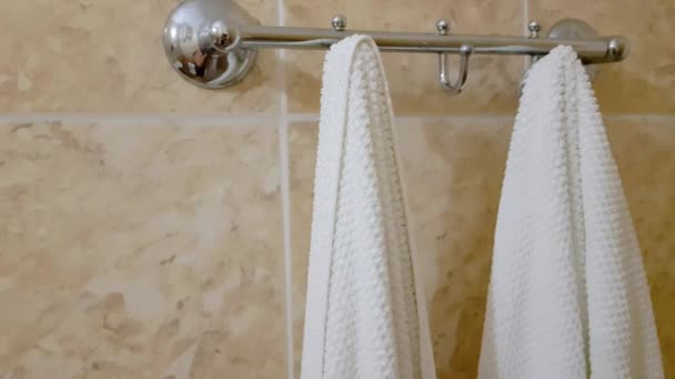 4k wideo, Metalowy uchwyt na ręczniki w łazience z dwoma białymi ręcznikami frotte - Materiał filmowy, wideo
