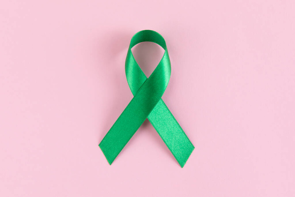 green ribbon on pink background - Foto, Imagem