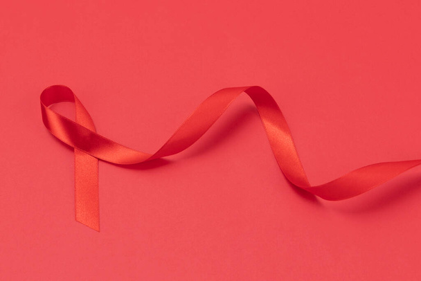 Red ribbon on red background - Fotoğraf, Görsel
