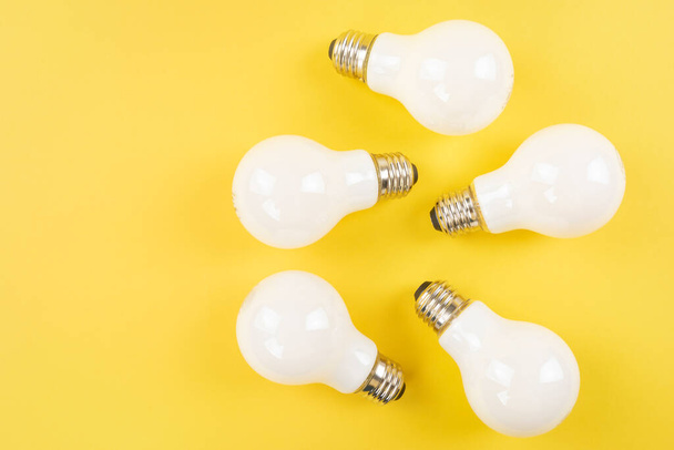 Opaque white bulbs on yellow background - Foto, Imagem