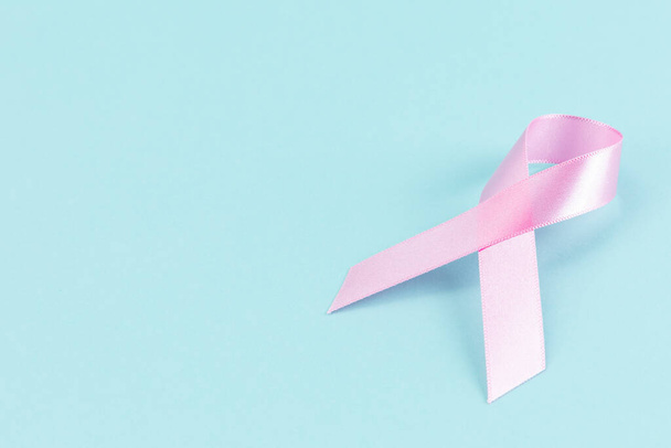 Pink ribbon on a mint color background - Foto, Bild