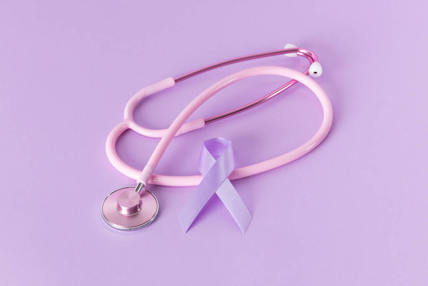 Pink stethoscope and purple ribbon, light purple background - Фото, изображение