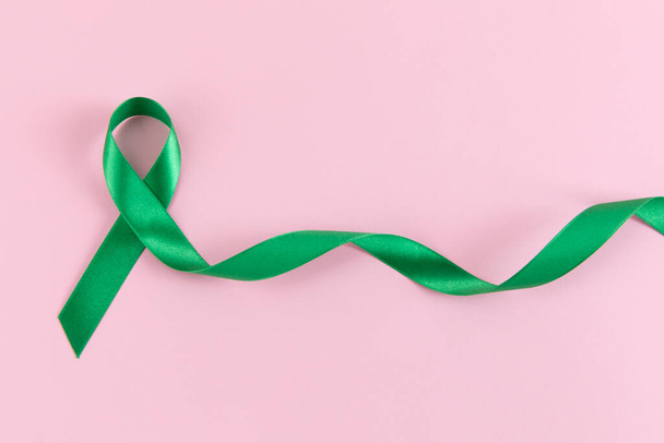 green ribbon on pink background - Zdjęcie, obraz