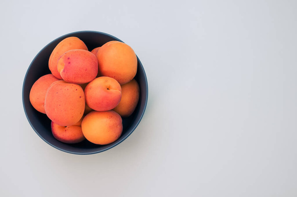 A top view of fresh apricots on a bowl isolated on white background with copy space - Φωτογραφία, εικόνα