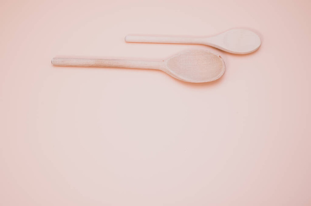 A top view of wooden spoons isolated on light pink background with copy spaace - Фото, изображение