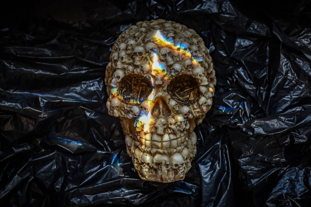 Play of light on a small decorative artificial human skull - Foto, afbeelding