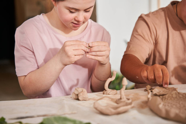 Girl with the down syndrome people feeling happy and working with clay - Valokuva, kuva