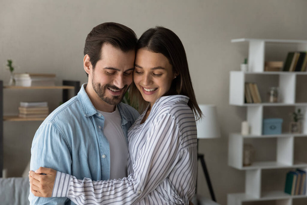 Couple in love cuddling standing inside of modern house - Photo, image