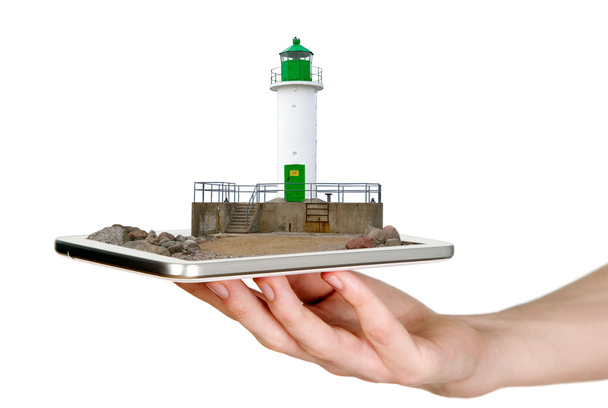 Man is showing white lighthouse with green details through mobile phone - Fotoğraf, Görsel