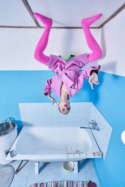Fashion woman wearing pink clothes standing at the ceiling at the interesting pose - 写真・画像