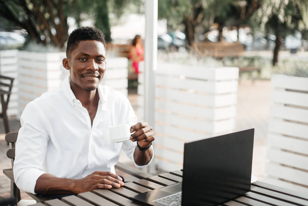 afrikanisch-amerikanischer Geschäftsmann, arbeitet am Laptop in einem Café, freiberuflich. - Foto, Bild